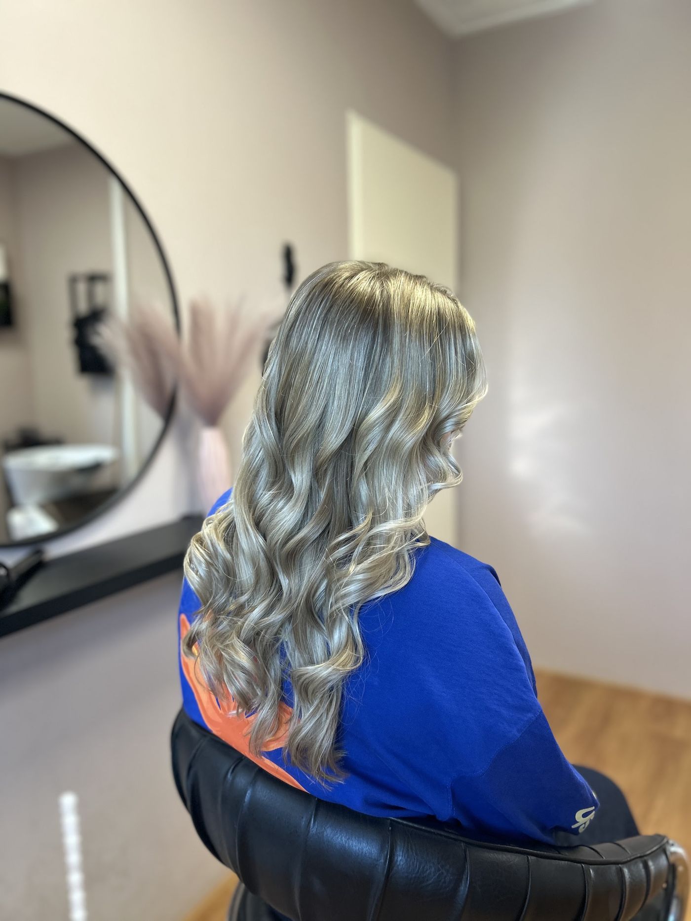 Lichtblonde krullen van achteren, in de salon