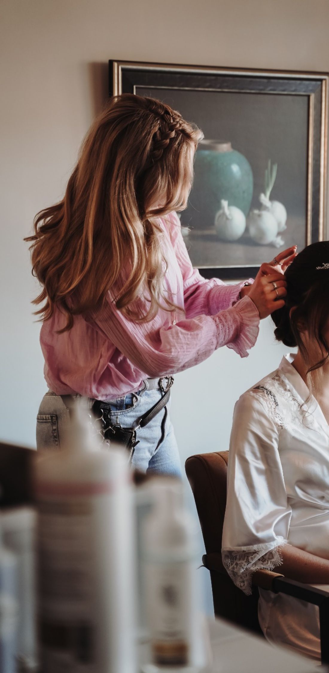 Luca speldt een opgestoken kapsel vast bij een klant in een witte satijnen kimono